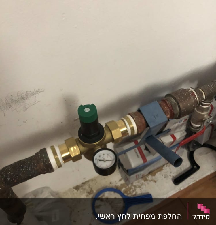 צינור עם מד לחץ וכלי עבודה של אינסטלטור